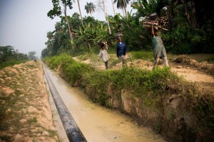 Iduma natives work along an oil pipe ditch